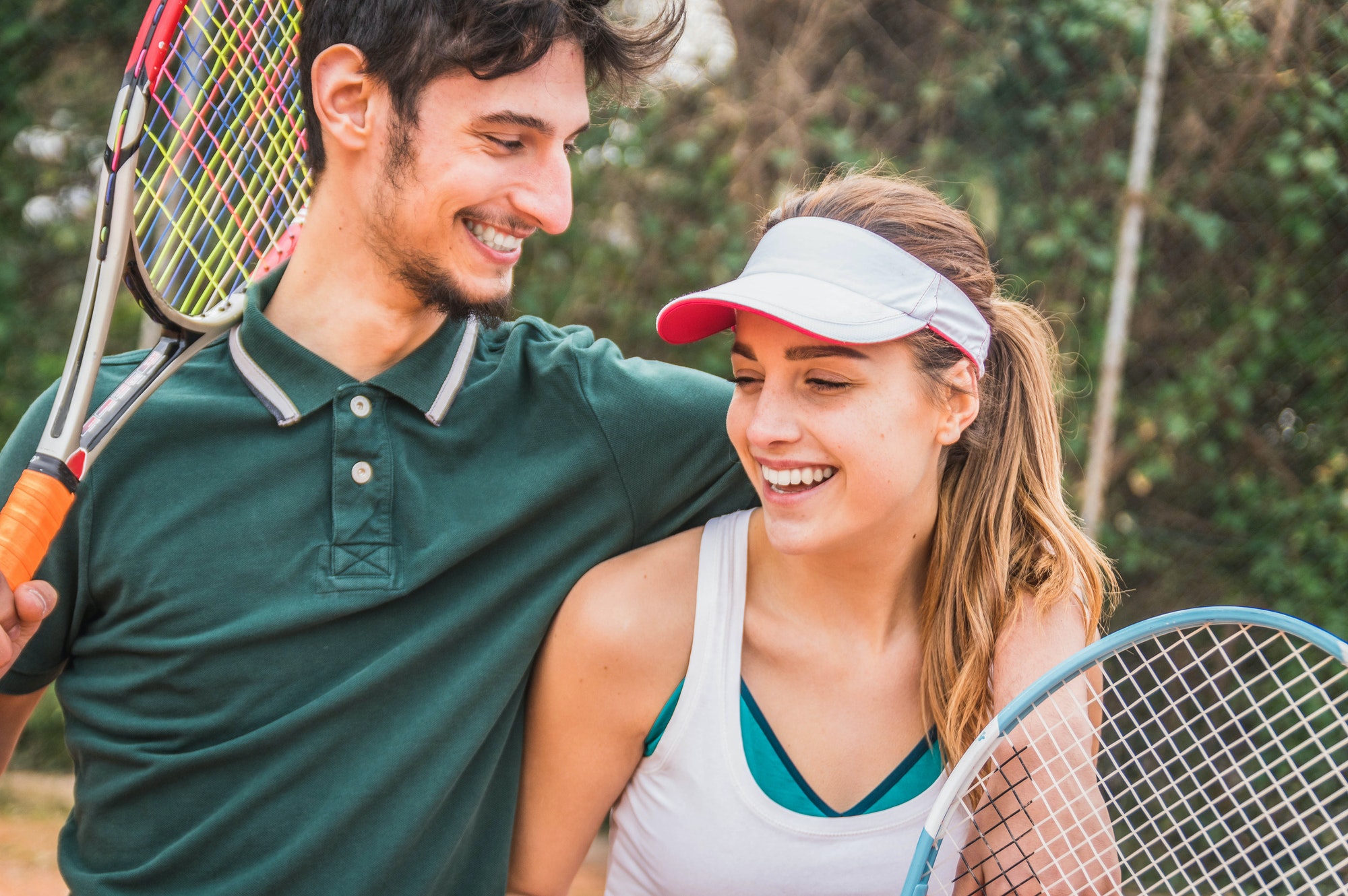 Happy young couple of tennis players having fun